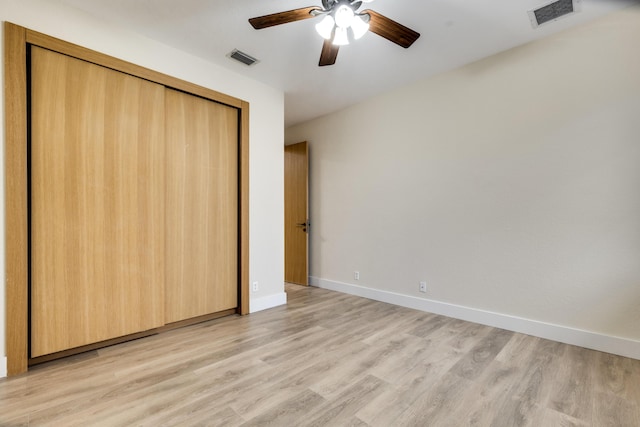 unfurnished bedroom with ceiling fan, a closet, and light wood-type flooring