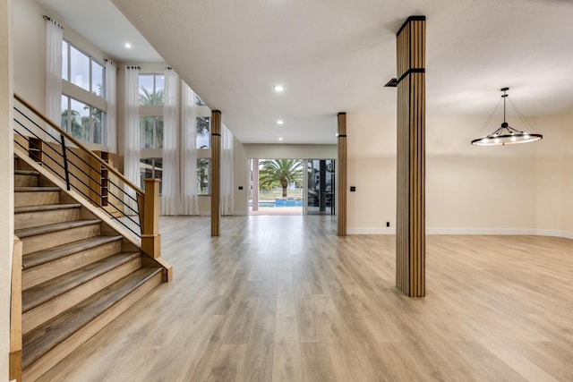 basement with light hardwood / wood-style floors, a notable chandelier, and a healthy amount of sunlight