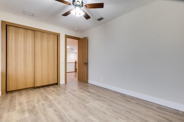 unfurnished bedroom featuring ceiling fan, a closet, and light wood-type flooring