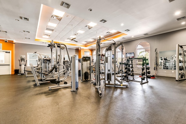 gym with crown molding and a raised ceiling