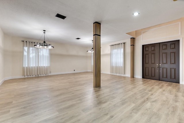 entryway featuring light hardwood / wood-style flooring and a chandelier