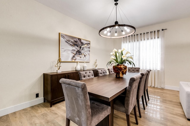 dining space featuring light wood-type flooring and a chandelier