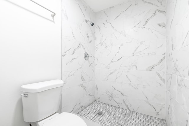 bathroom featuring tiled shower and toilet