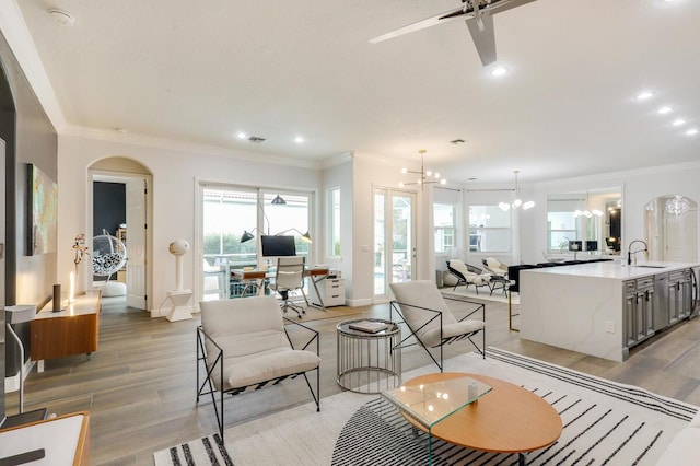 living room with sink, crown molding, and light hardwood / wood-style flooring