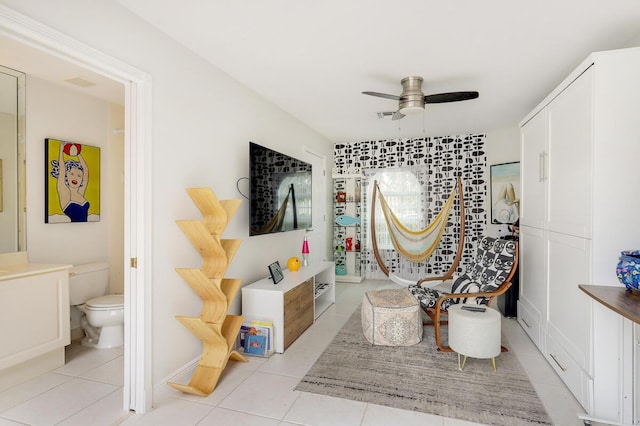 sitting room with ceiling fan and light tile patterned floors