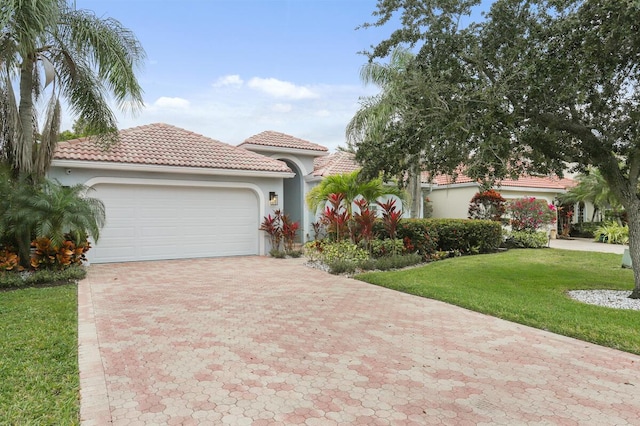 mediterranean / spanish house featuring a front yard and a garage