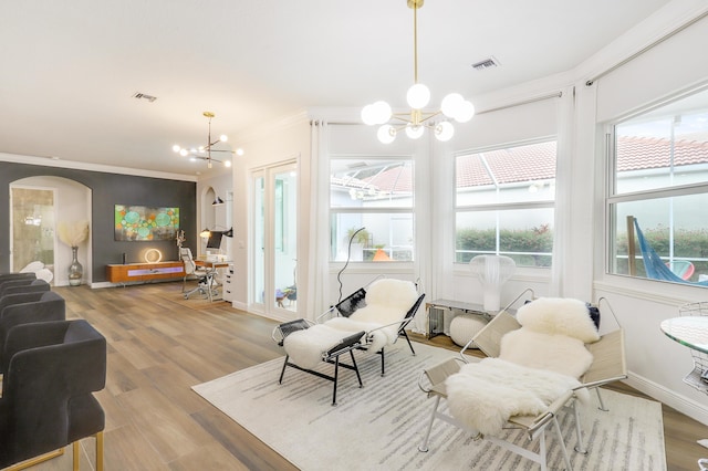 interior space with hardwood / wood-style floors, crown molding, and a notable chandelier