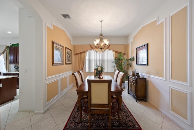 tiled dining area featuring a chandelier