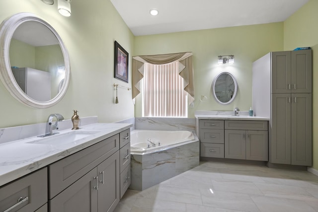 bathroom with vanity and tiled bath