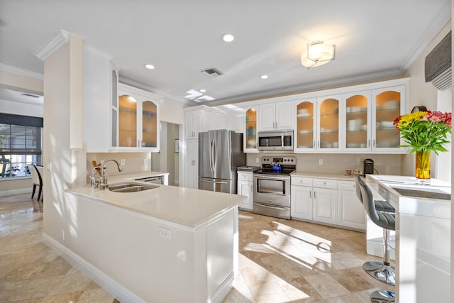 kitchen with crown molding, appliances with stainless steel finishes, white cabinets, and kitchen peninsula