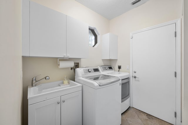 laundry room featuring cabinets, independent washer and dryer, sink, and a textured ceiling