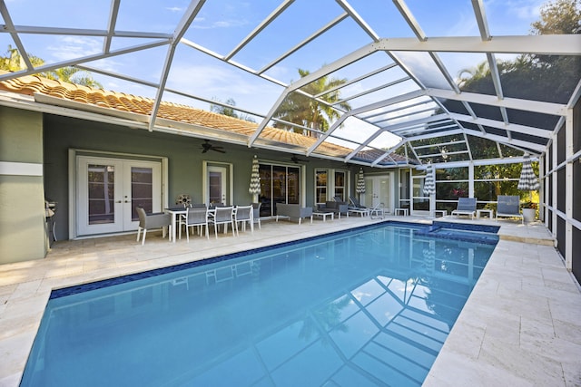 view of swimming pool with french doors, a lanai, and a patio area