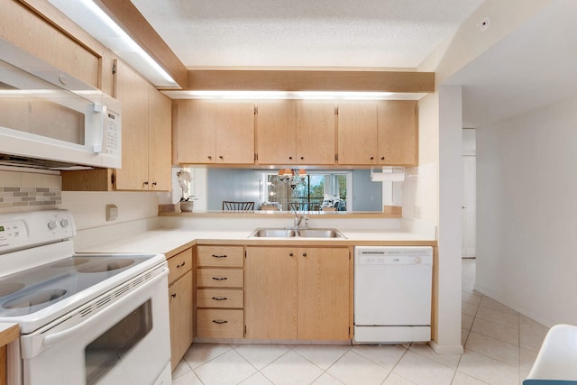 kitchen featuring light brown cabinetry, sink, white appliances, and a textured ceiling