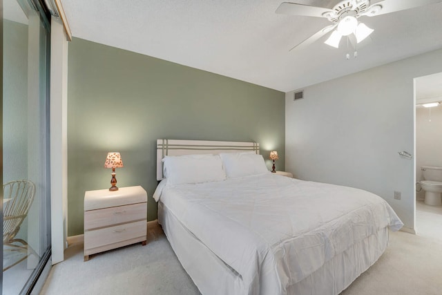 carpeted bedroom with ceiling fan, ensuite bath, and baseboard heating