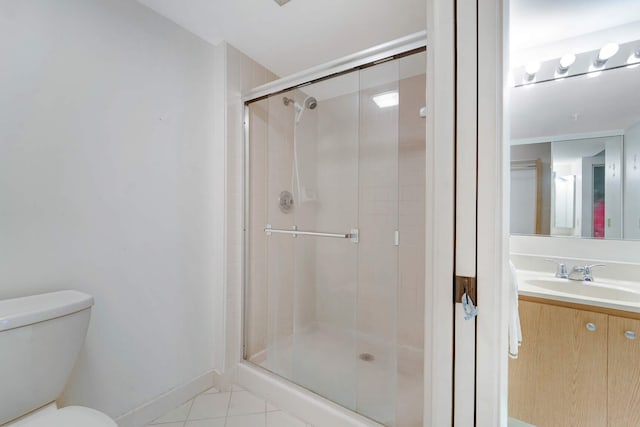 bathroom with tile patterned floors, toilet, a shower with shower door, and vanity