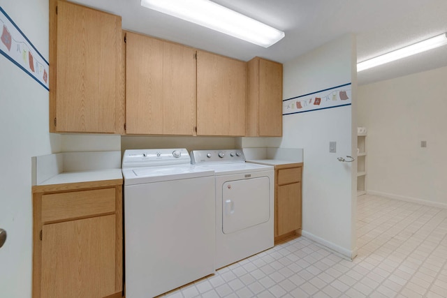 washroom featuring cabinets and washing machine and clothes dryer