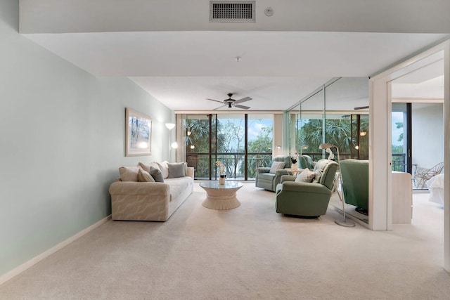 carpeted living room with expansive windows and ceiling fan