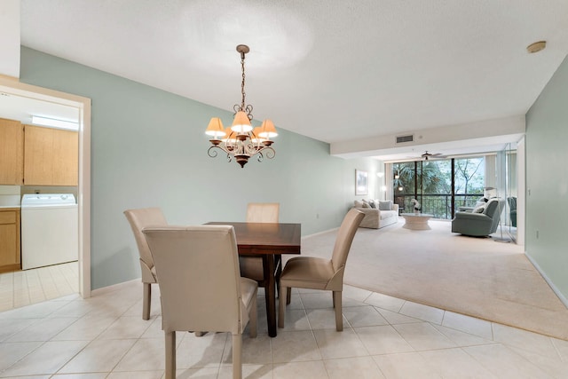 dining area with an inviting chandelier, washer / dryer, and light colored carpet