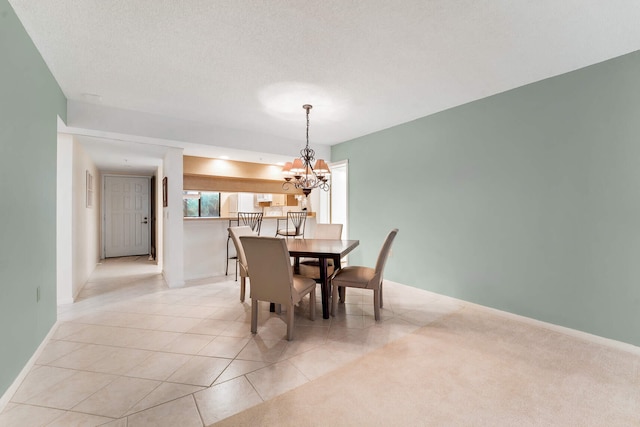 tiled dining space featuring a textured ceiling and an inviting chandelier