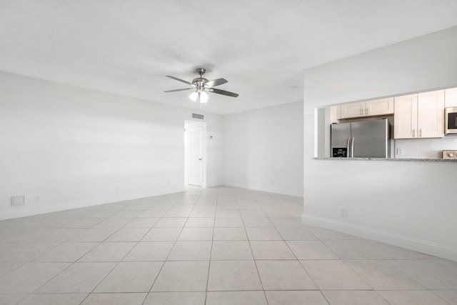 empty room featuring ceiling fan and light tile patterned floors