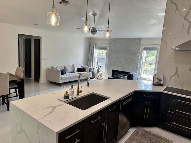 kitchen with light stone counters, black appliances, a healthy amount of sunlight, and sink