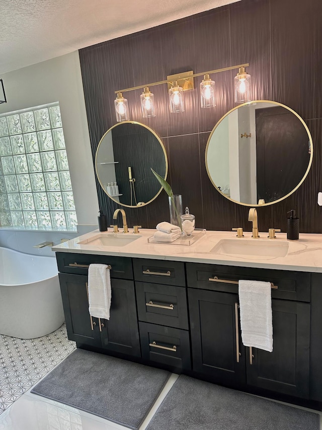 bathroom with vanity, a textured ceiling, and a bath