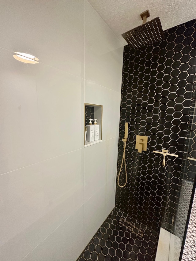 bathroom with a shower and a textured ceiling