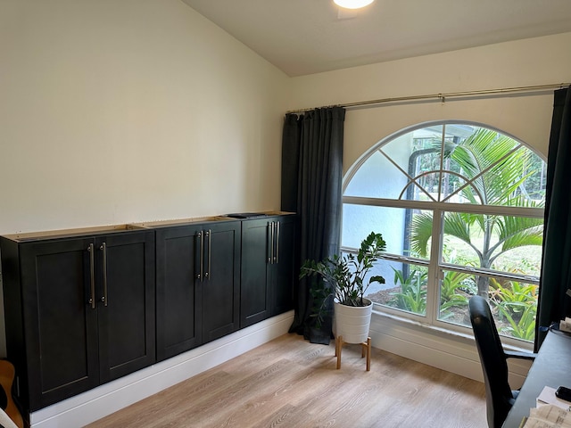 office space featuring vaulted ceiling and light hardwood / wood-style floors