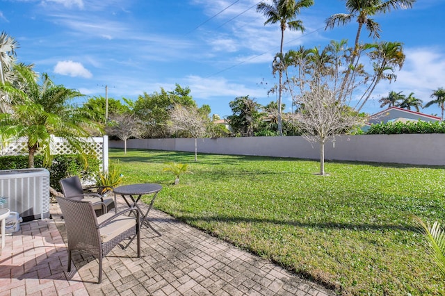 view of yard featuring central AC unit and a patio