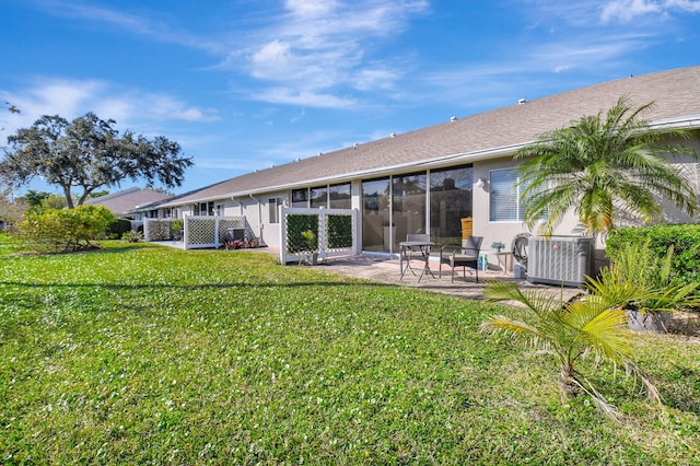 back of property featuring central AC unit, a lawn, and a patio area