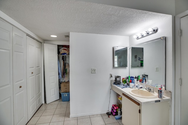 bathroom featuring a textured ceiling, tile patterned floors, and vanity