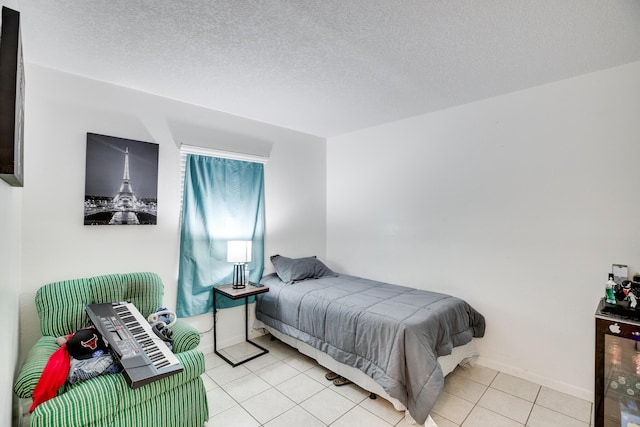 bedroom with light tile patterned flooring and a textured ceiling