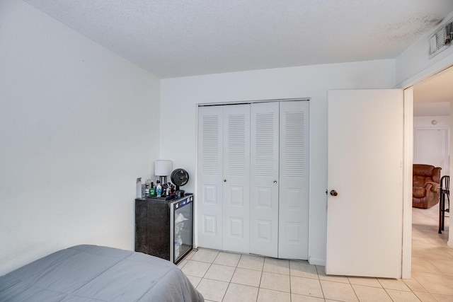 tiled bedroom featuring a closet and a textured ceiling