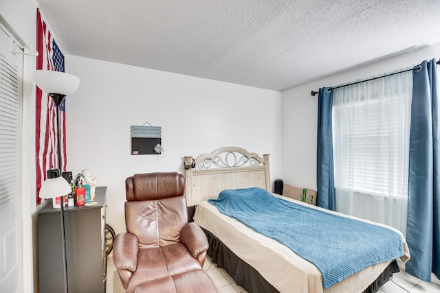 tiled bedroom with a textured ceiling