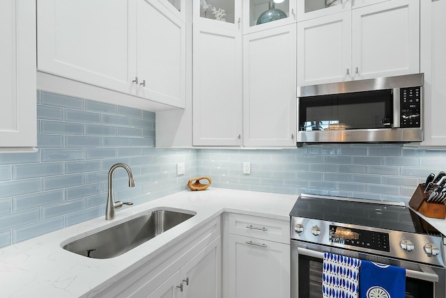 kitchen featuring stainless steel appliances, white cabinets, and sink