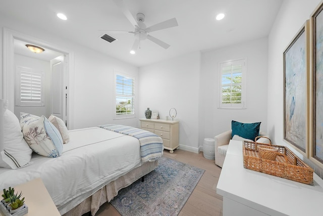 bedroom featuring light wood-type flooring, ceiling fan, and multiple windows