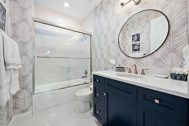 full bathroom featuring toilet, vanity, and bath / shower combo with glass door