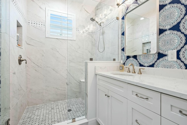 bathroom with a tile shower and vanity