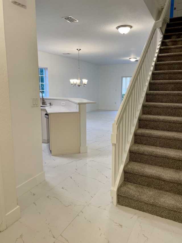 stairs with a notable chandelier and sink