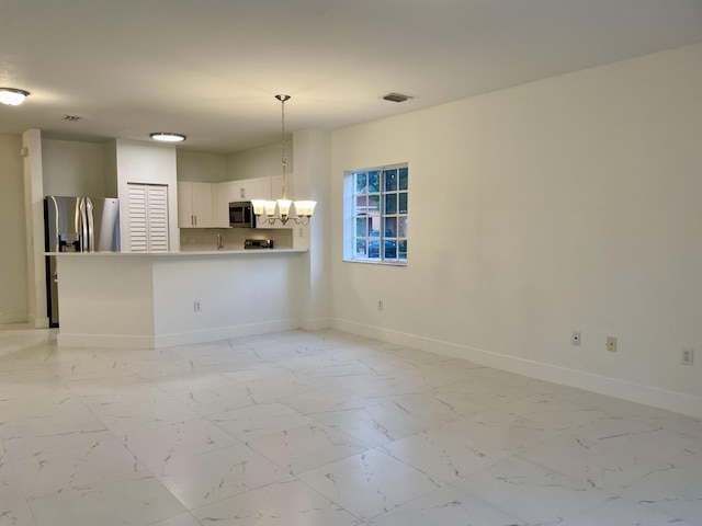 unfurnished living room featuring a notable chandelier