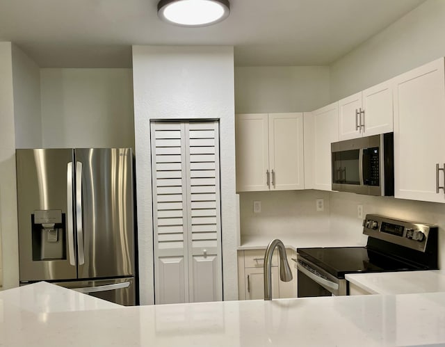 kitchen with appliances with stainless steel finishes, sink, and white cabinetry