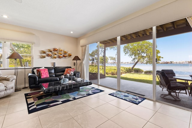 tiled living room featuring a water view