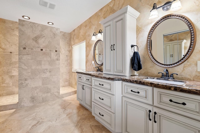 bathroom featuring vanity, tile walls, and a tile shower