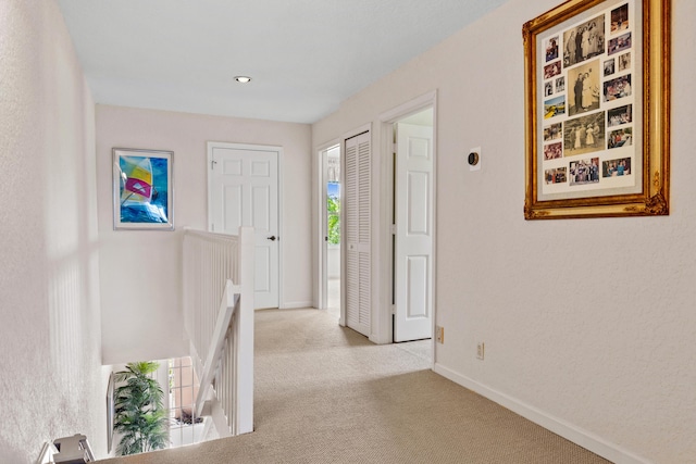 hall with light colored carpet