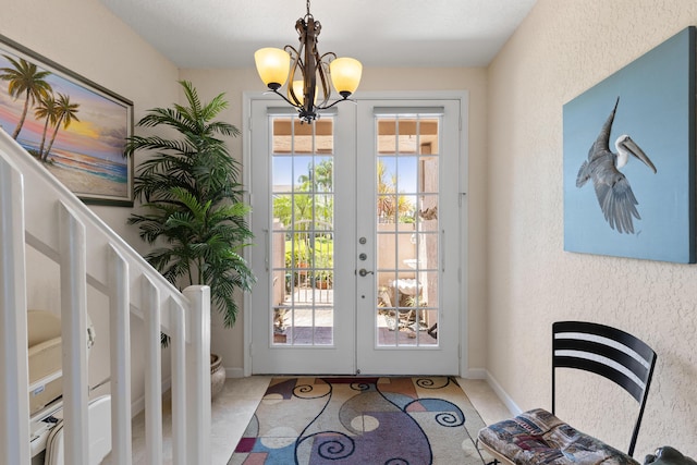 entryway with a notable chandelier and french doors