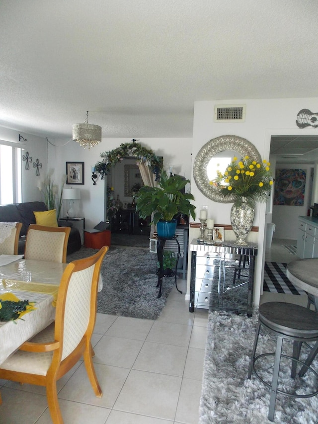 tiled dining space with a textured ceiling