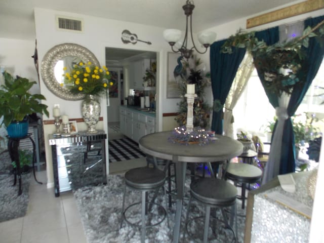 dining space featuring light tile patterned floors and an inviting chandelier