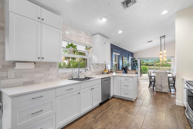 kitchen featuring appliances with stainless steel finishes, white cabinets, sink, and kitchen peninsula