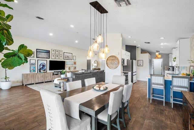 dining space with a textured ceiling, dark hardwood / wood-style flooring, and sink