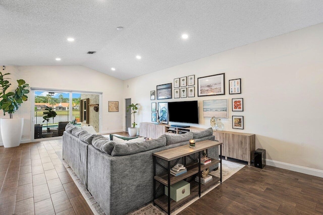 living room with a textured ceiling, vaulted ceiling, and wood-type flooring